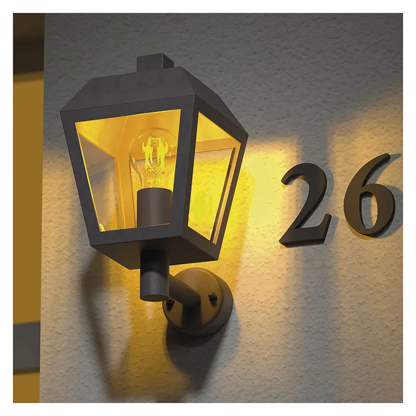 Egy sötét fali lámpa világít a 26-os házszámok mellett egy falon.