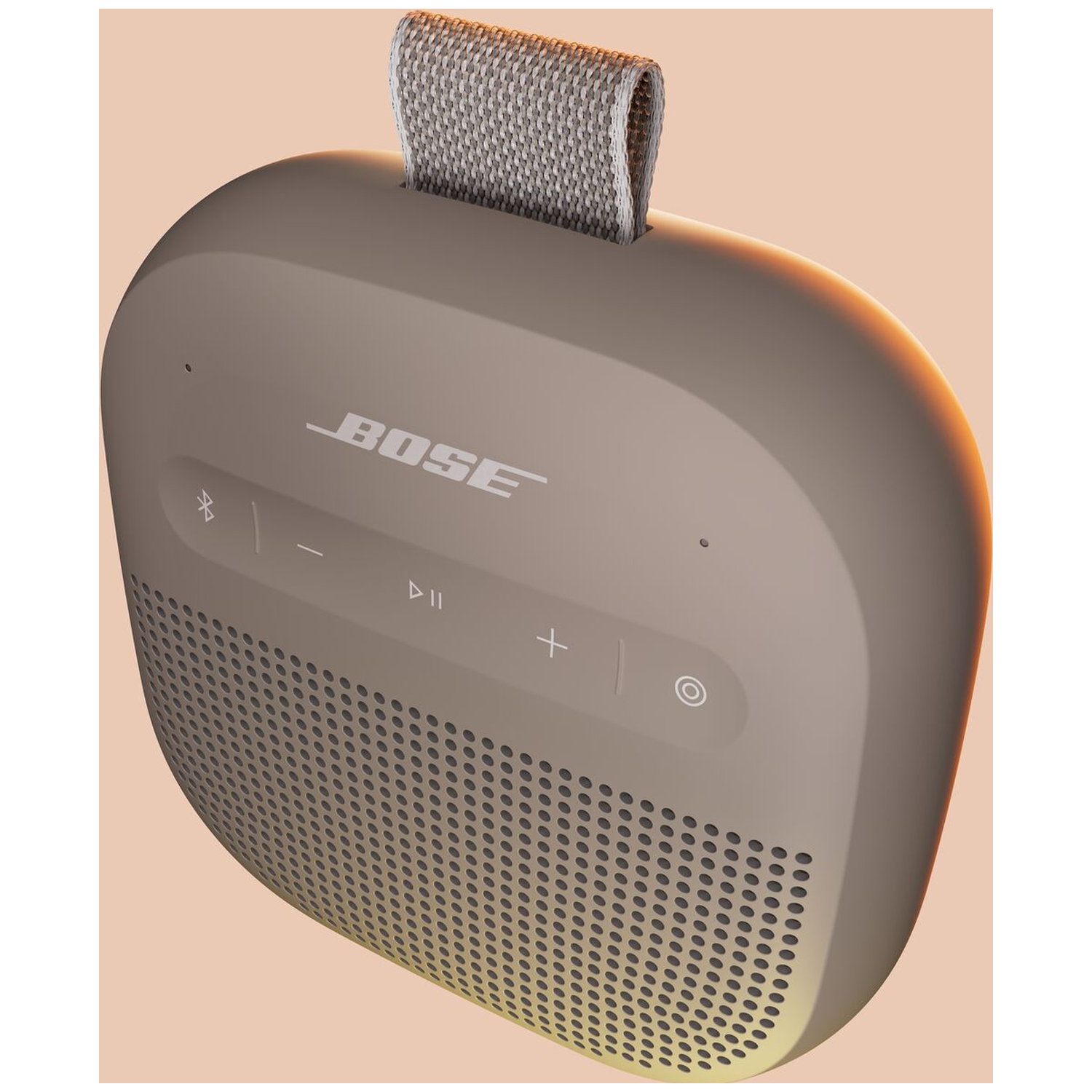 Een taupe Bose speaker met stoffen lus en bedieningsknoppen.