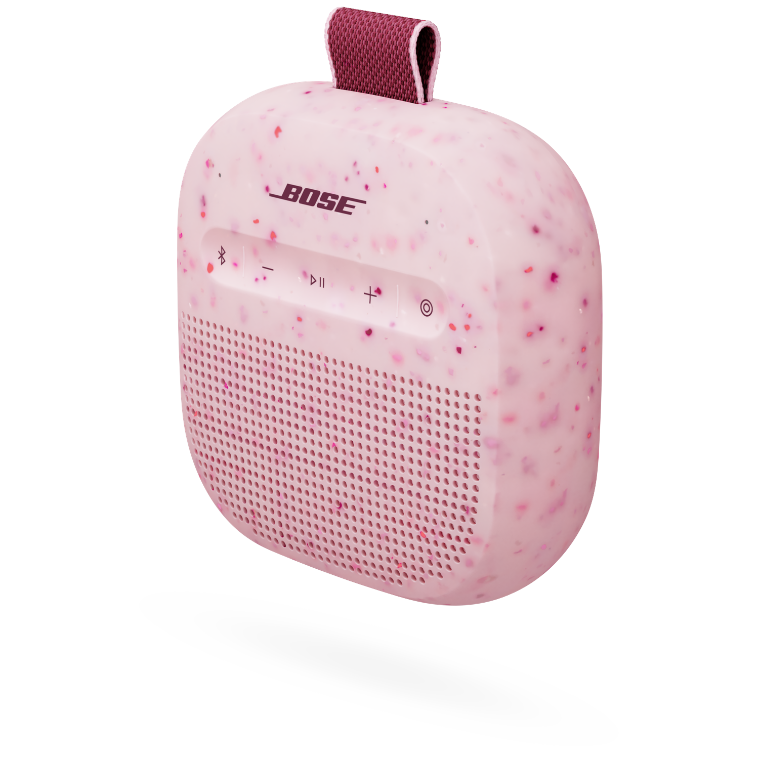 Een roze Bose speaker met spikkels en draagband.