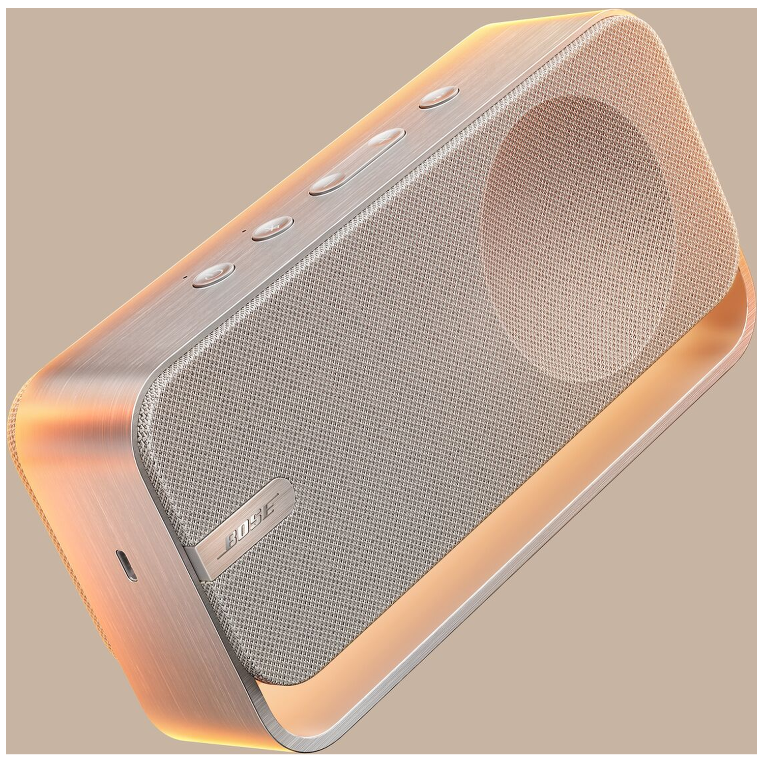 A silver Bose speaker with a grey fabric grille and a copper-colored frame.