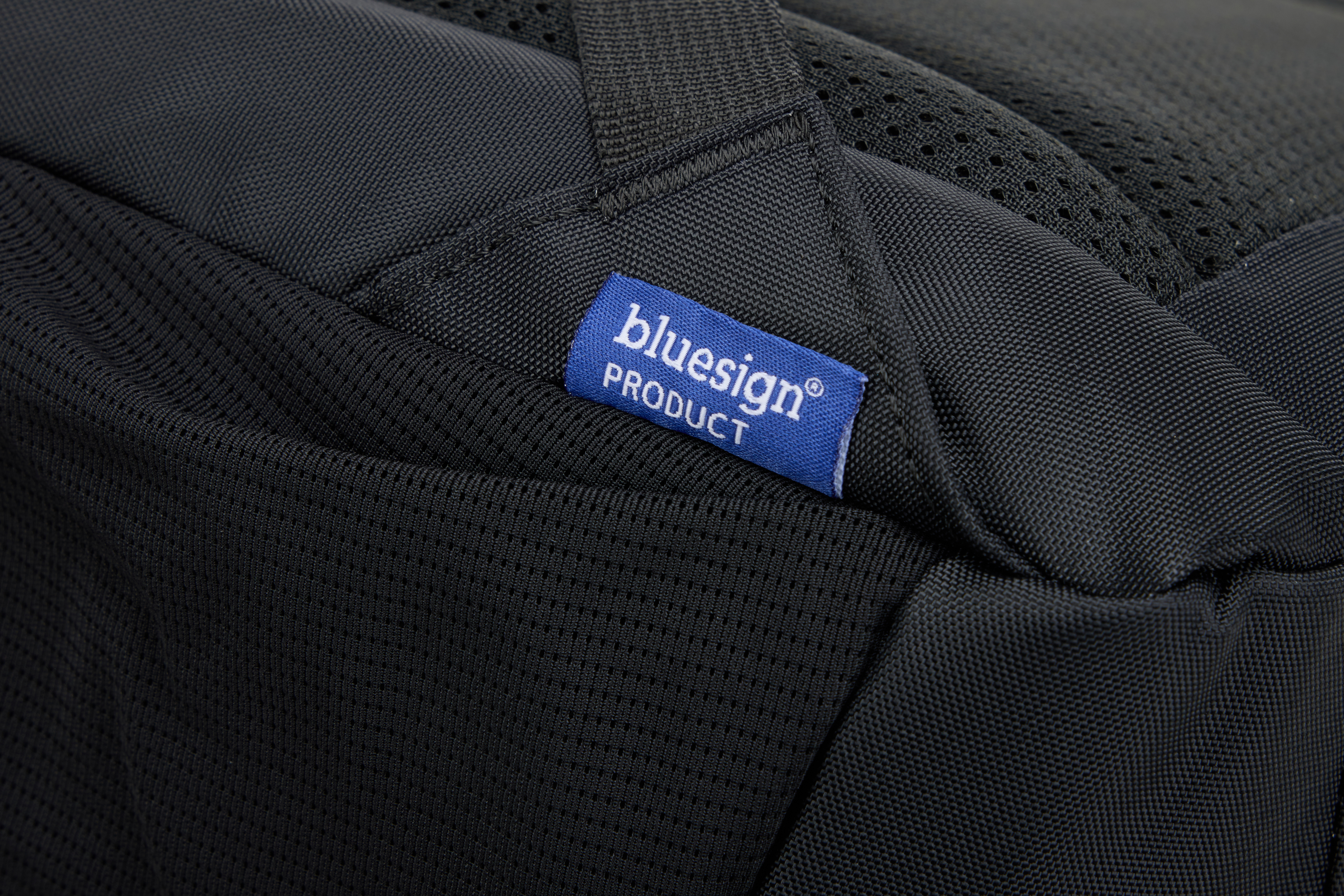 Siyah dokulu kumaş üzerinde mavi bluesign® PRODUCT etiketi.
