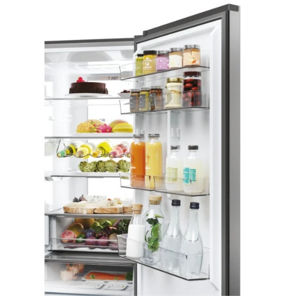 Estantes de refrigerador llenos con frascos, botellas y cajones de frutas.