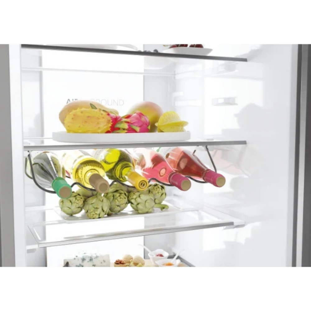 Estante de refrigerador con botellas, alcachofas y fruta. Queso en el estante inferior.