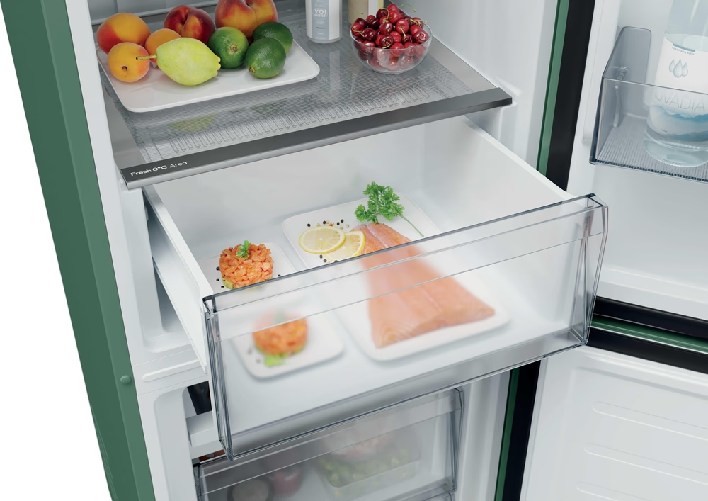 Grüner Kühlschrank mit einer Schublade mit Lachs, Zitronenscheiben und Kräutern.