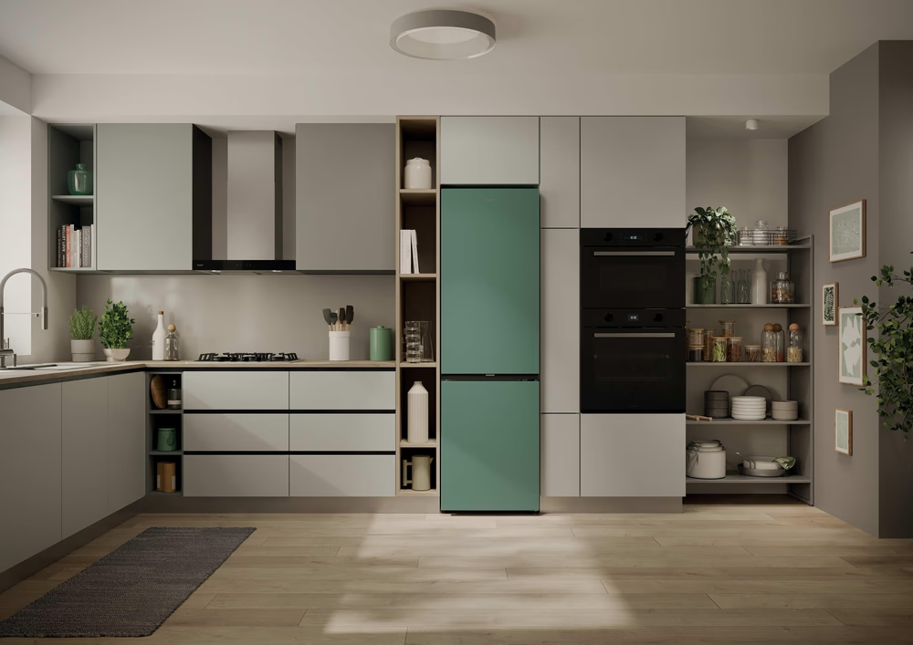 Moderne Küche mit grünen und grauen Schränken, Gasherd, Öfen und Kühlschrank.