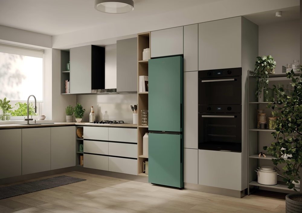 Moderne Küche mit grünem Kühlschrank, schwarzen Öfen und hellgrauen Schränken.