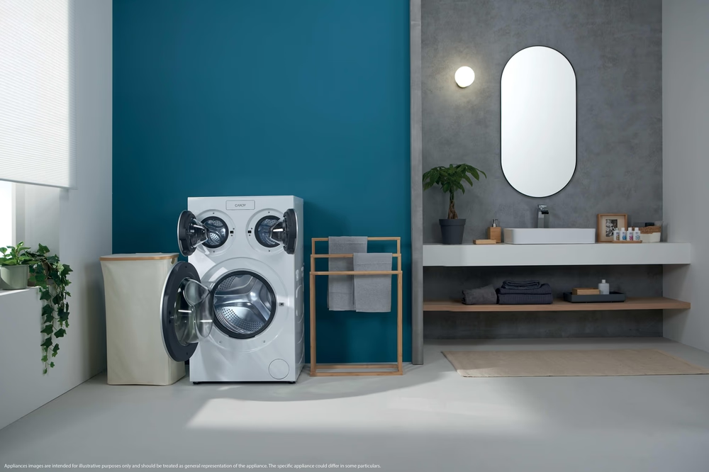 Une salle de bain avec machine à laver, panier à linge et lavabo.