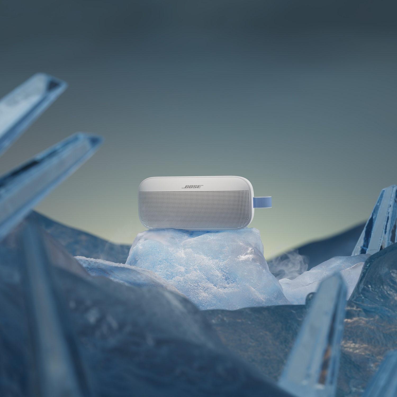 Een witte Bose luidspreker op ijs, met blauwe ijsscherven op de voorgrond.