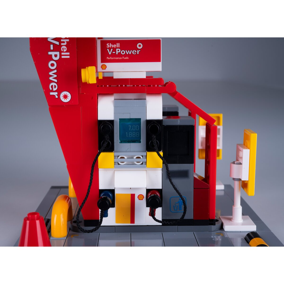 Egy Lego Shell benzinkút modell piros és fehér kútoszlopokkal.