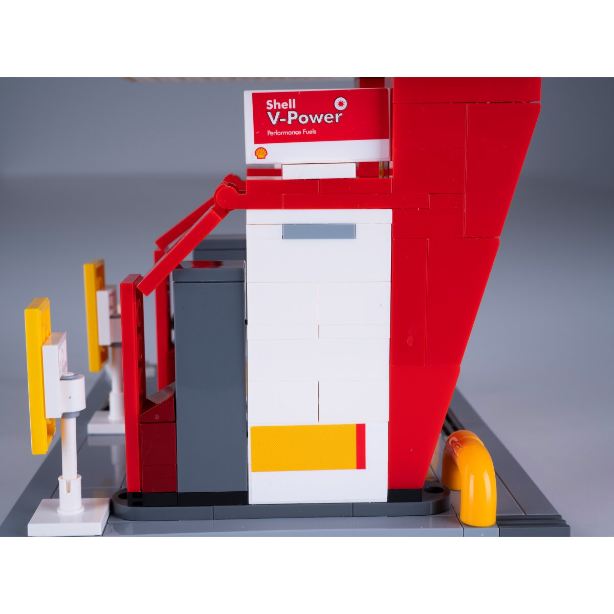 Egy Shell benzinkút Lego modellje piros és fehér szivattyúkkal.