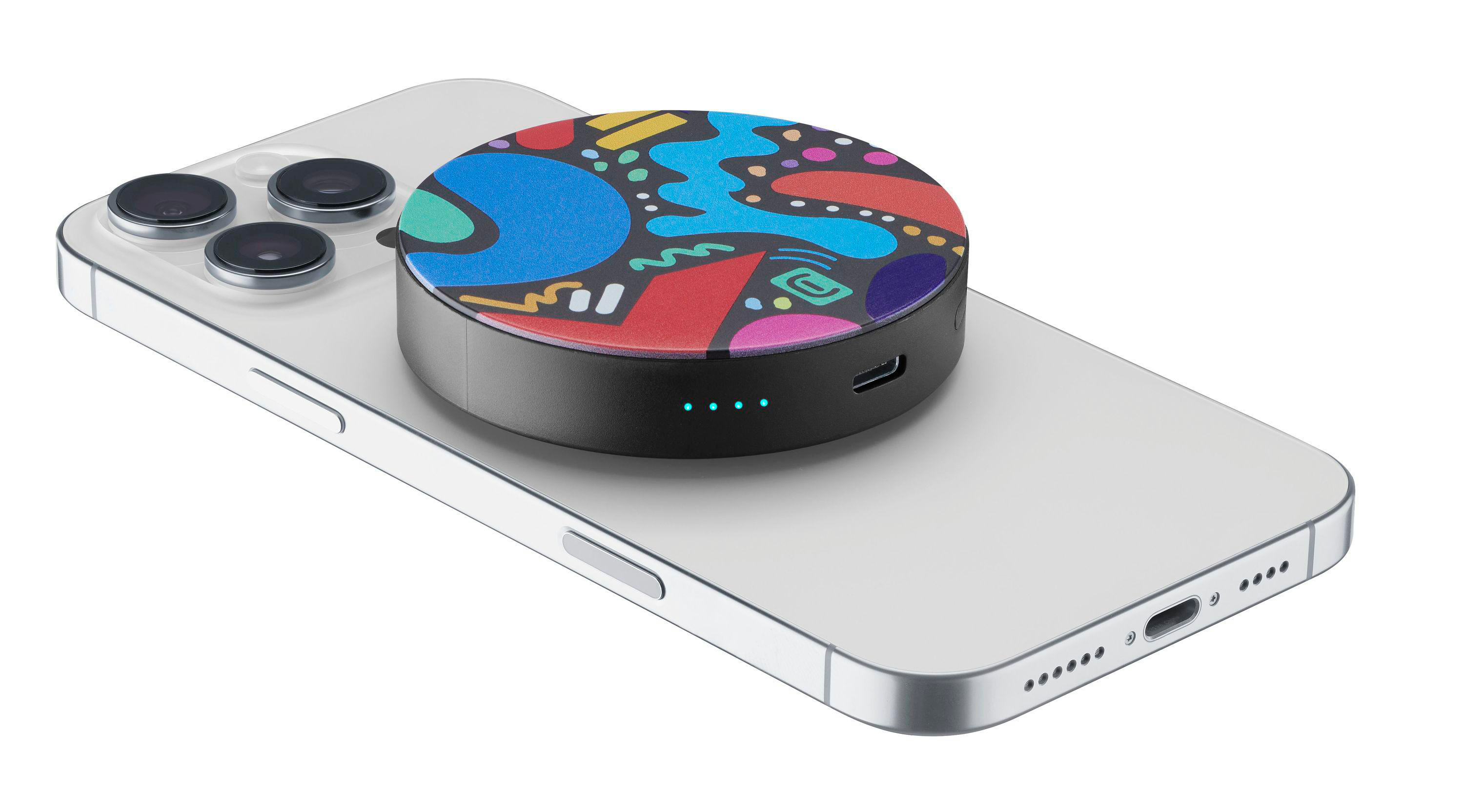 Ein weißes Smartphone mit einer bunten, runden Powerbank darauf.