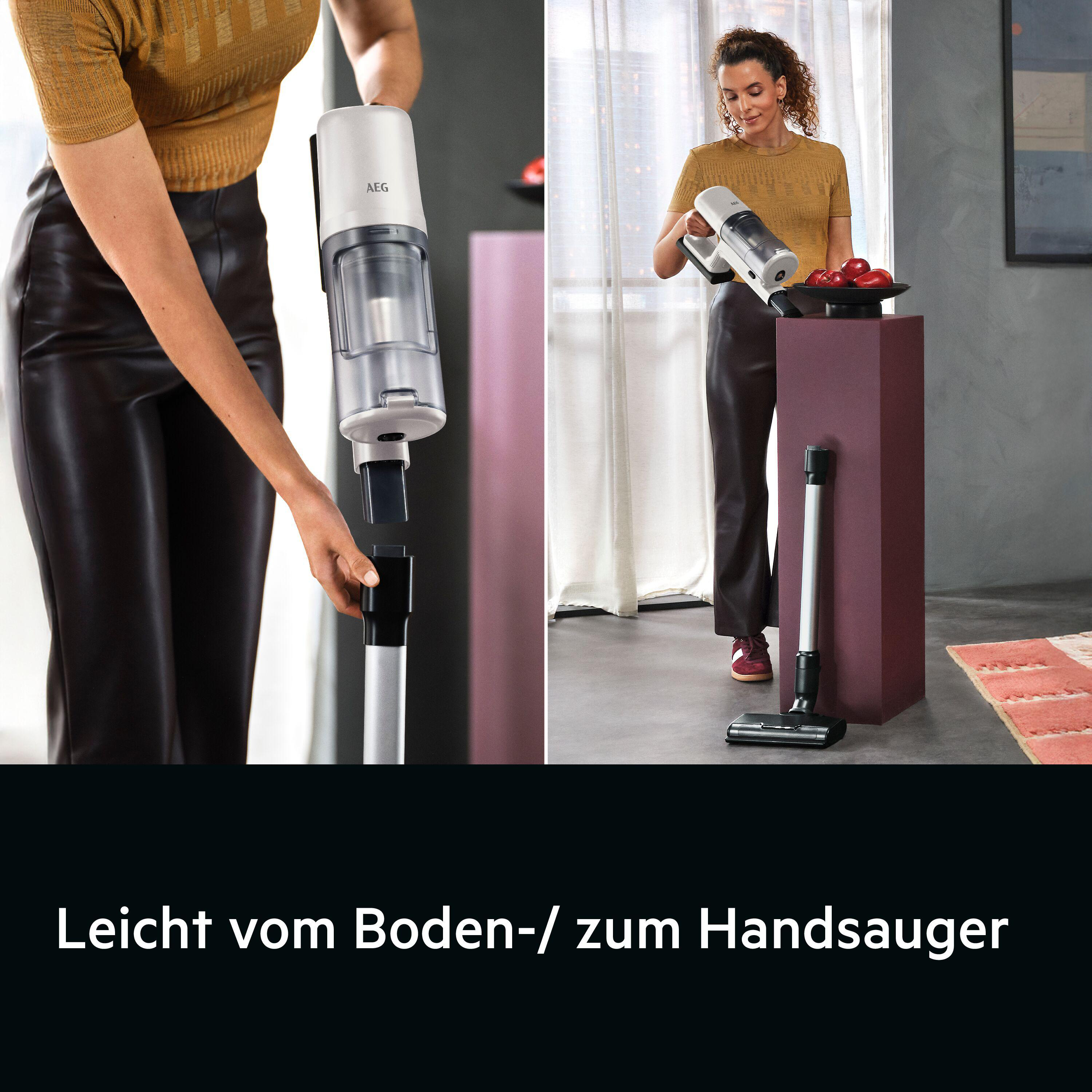 Eine Frau in einem gelben Oberteil und Lederrock montiert einen AEG-Staubsauger.