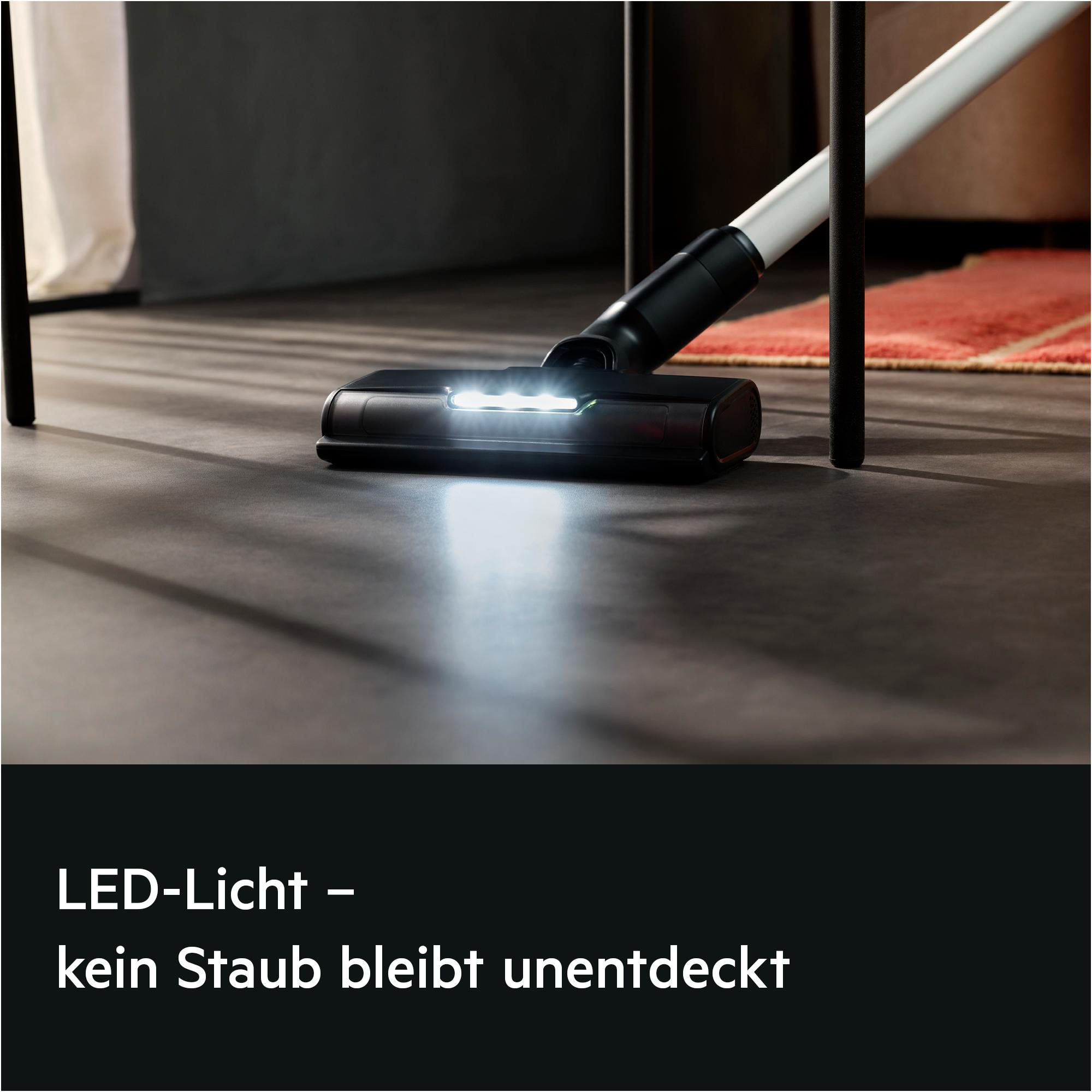 Staubsaugerdüse mit LED-Licht auf dunklem Boden.