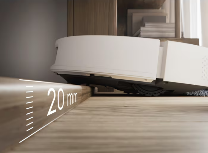 Egy fehér robotporszívó 20 mm-es küszöböt mászik meg fapadlón.