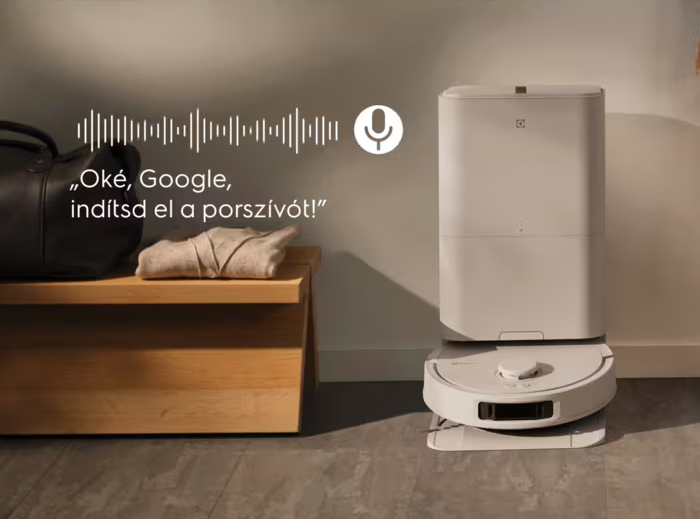 Robotporszívó töltőállomással egy fa pad mellett, táskával és ruhákkal.