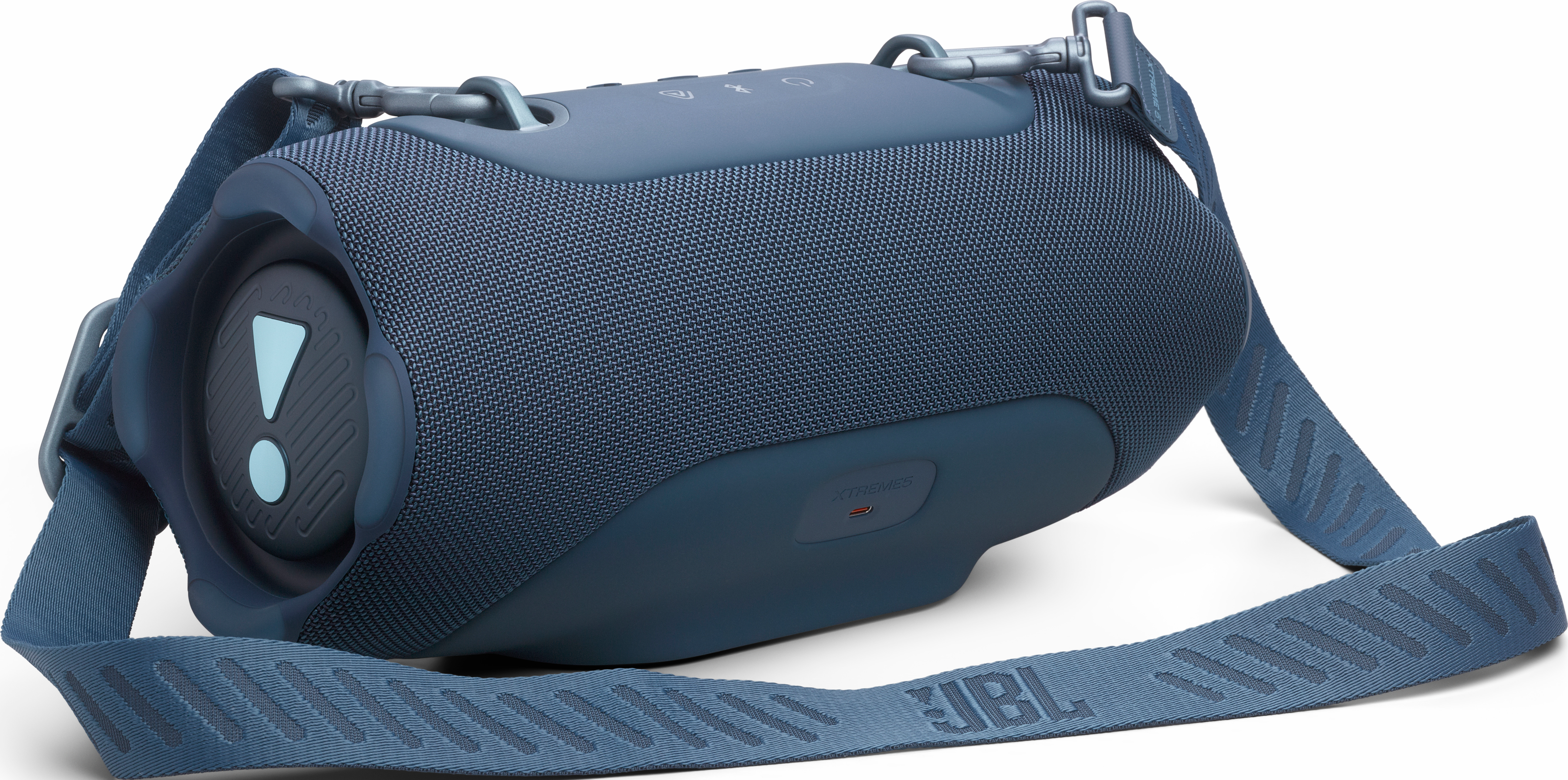 Ein blauer JBL-Lautsprecher mit Tragegurt liegt auf weißem Hintergrund.