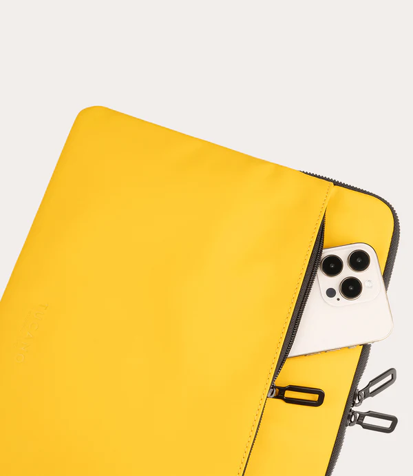Un bolso amarillo con cremallera, parcialmente abierto, que revela un smartphone.