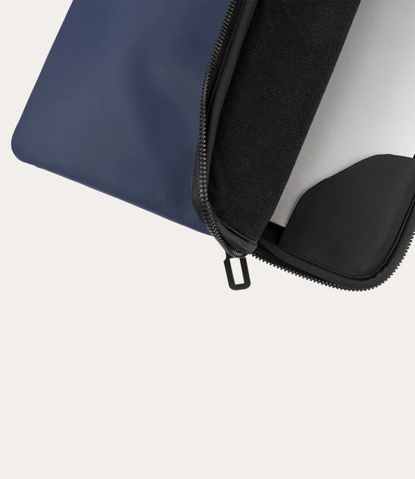 Funda azul marino para portátil, parcialmente abierta, mostrando forro interior negro.