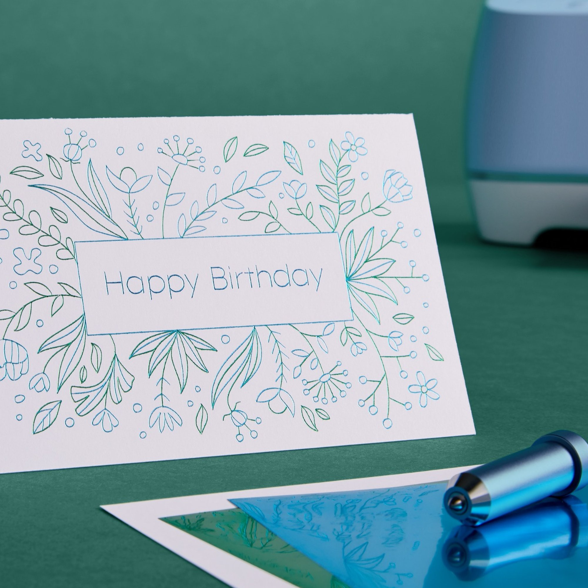 Una tarjeta de cumpleaños con diseño floral y herramienta sobre fondo verde.