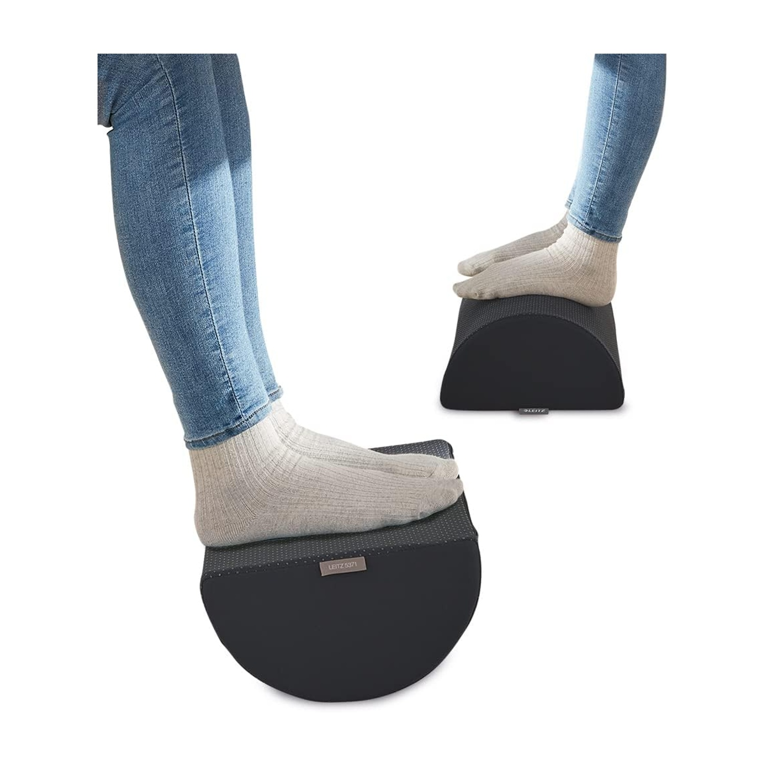 Persona in jeans e calzini su due poggiapiedi neri.