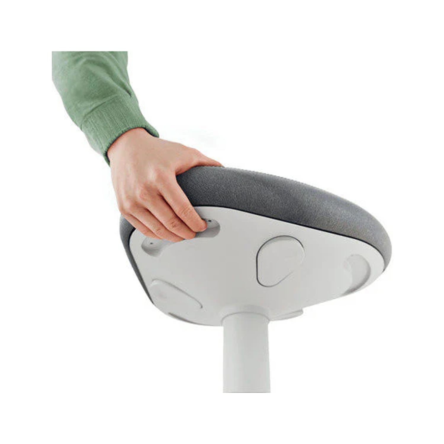 Una mano in un maglione verde afferra un sedile grigio su uno sgabello bianco.