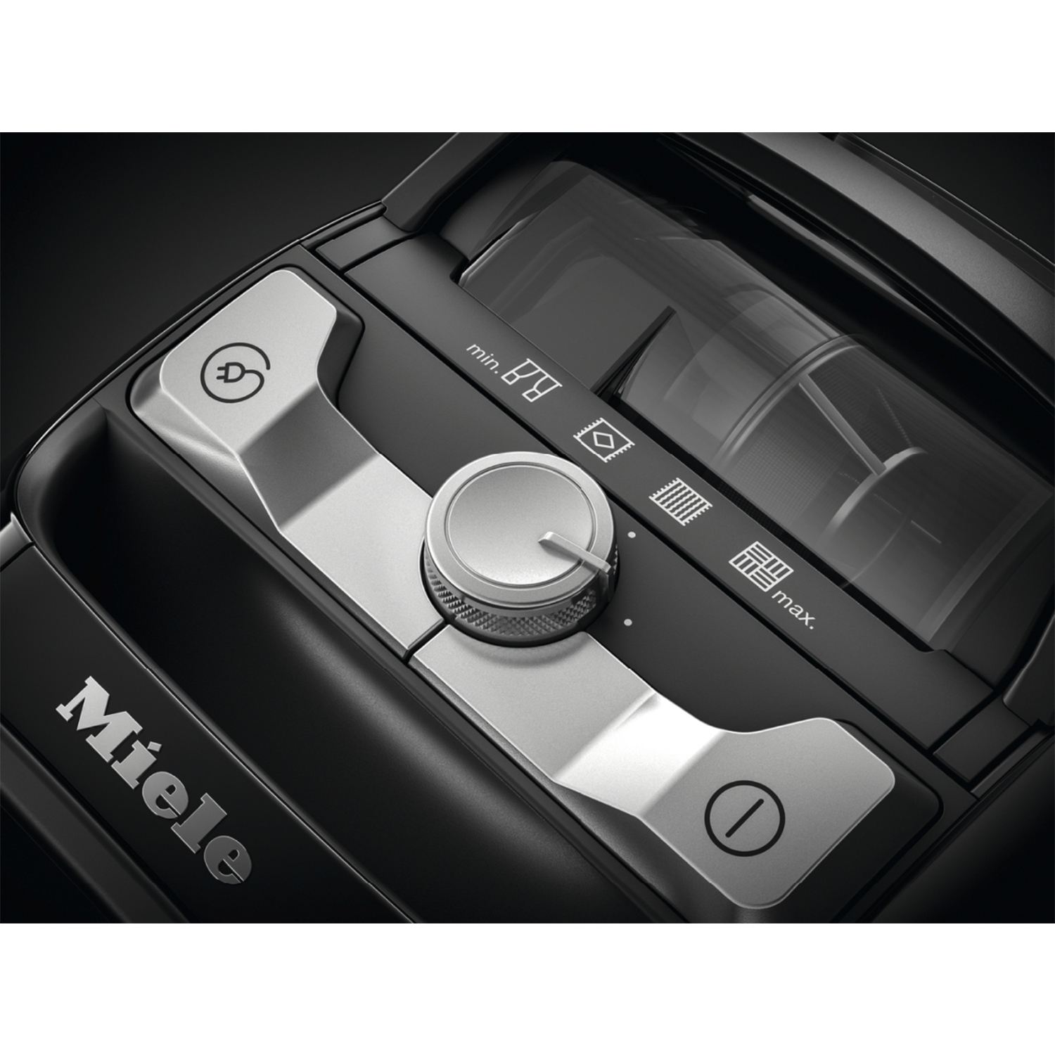 Primo piano del pannello di controllo di un aspirapolvere Miele nero con accenti e pulsanti argentati.