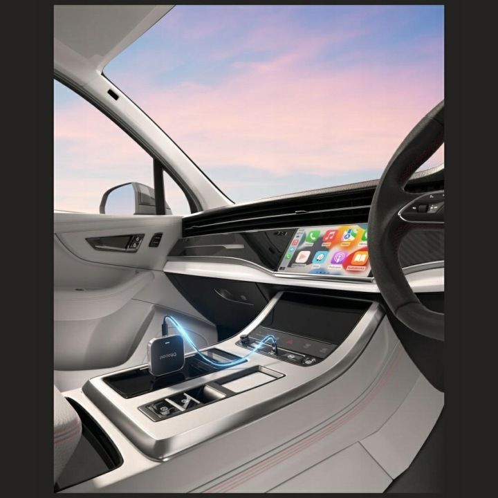 Wnętrze samochodu z deską rozdzielczą, ekranem i kierownicą.