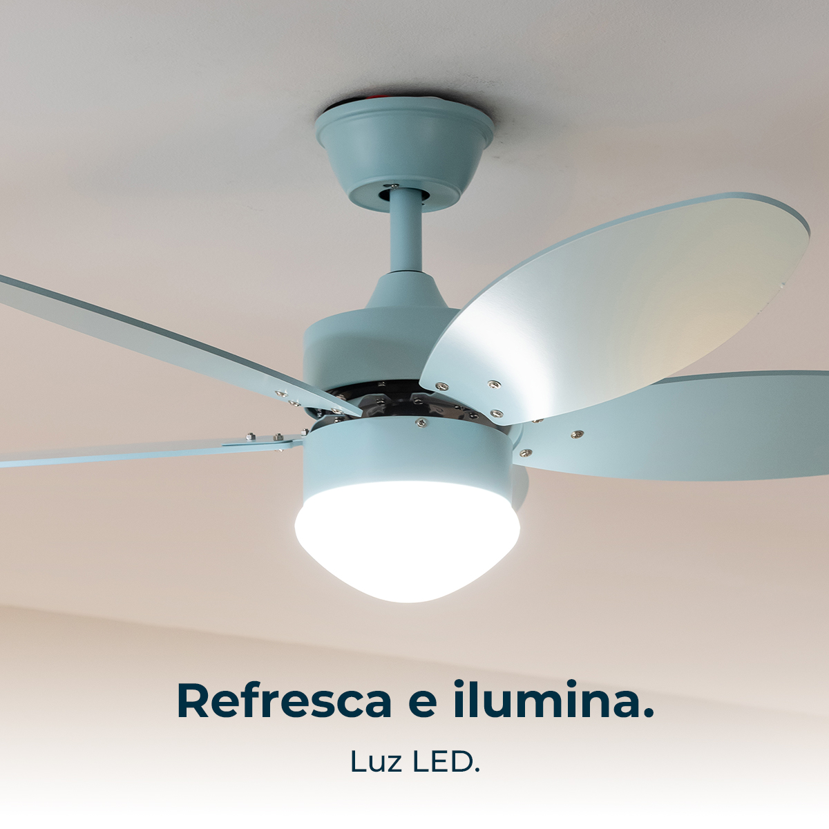 Un ventilador de techo azul claro con luz LED está montado en un techo blanco.