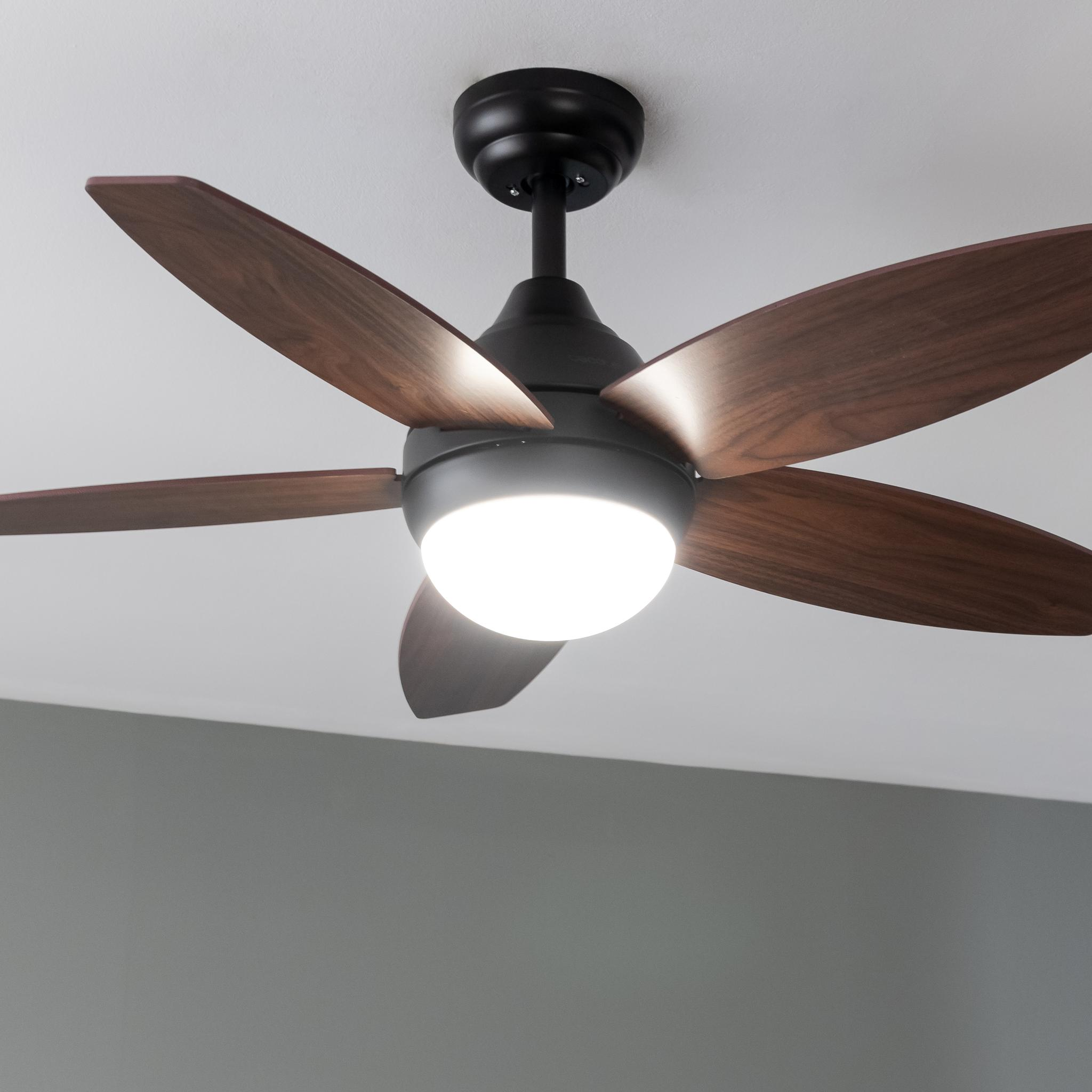 Un ventilador de techo con cinco aspas de madera y una luz central.