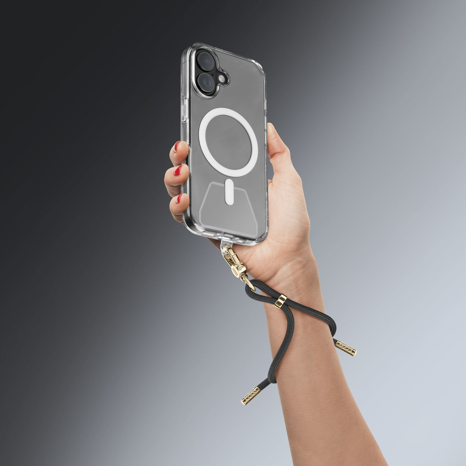 Una mano sostiene un teléfono transparente con cordón negro y detalles dorados.