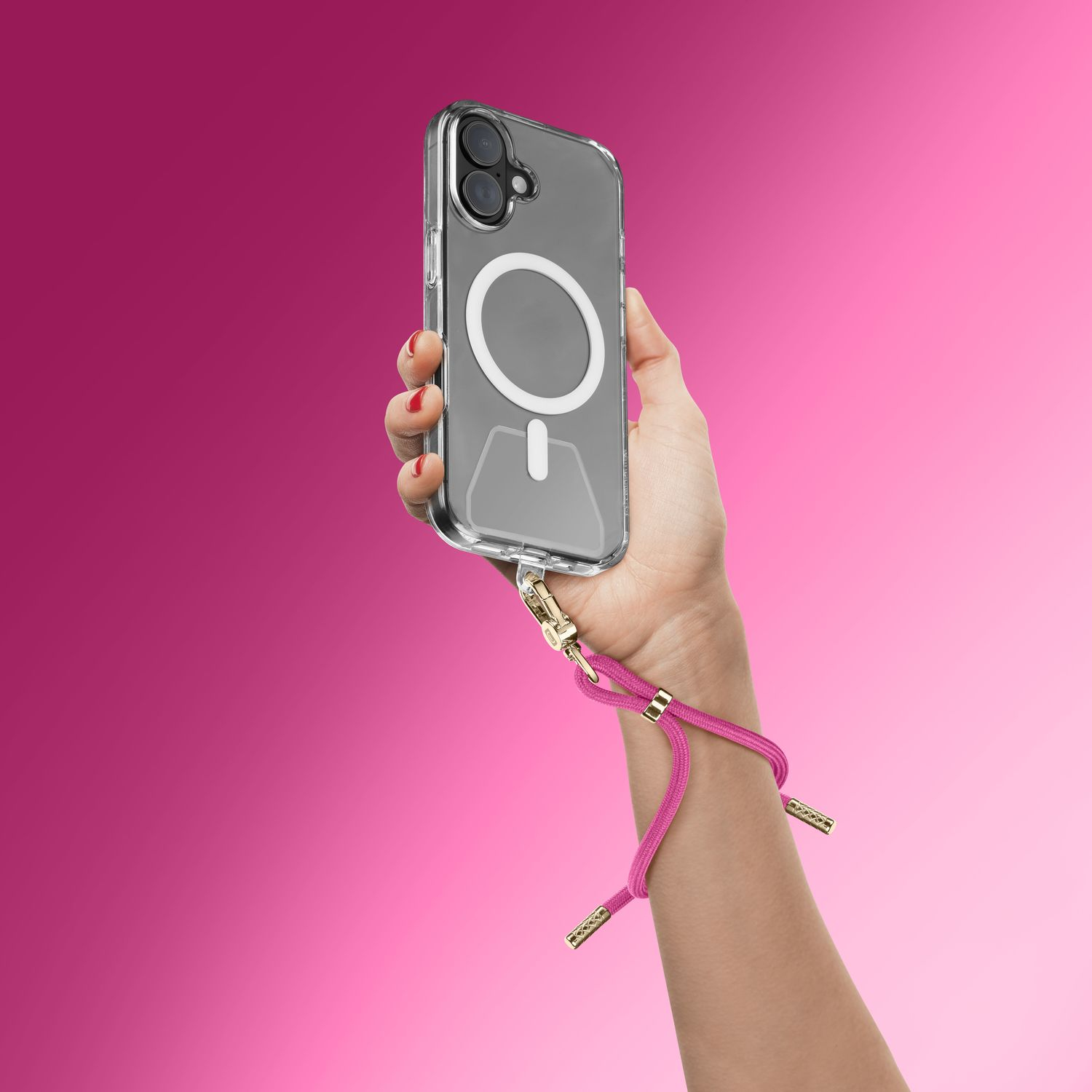 Una mano sostiene un smartphone con funda y correa de muñeca rosa.
