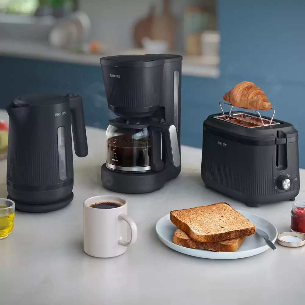 Czajnik, ekspres do kawy, toster z rogalikiem, kubek kawy, tost, dżem.