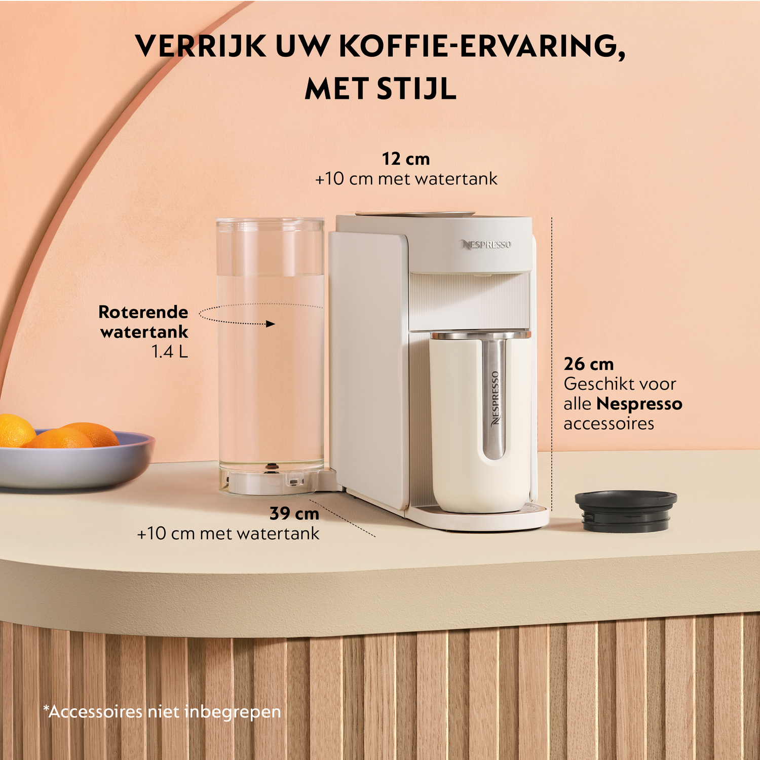 A white Nespresso machine with a water tank, glass, and fruit bowl on a counter.