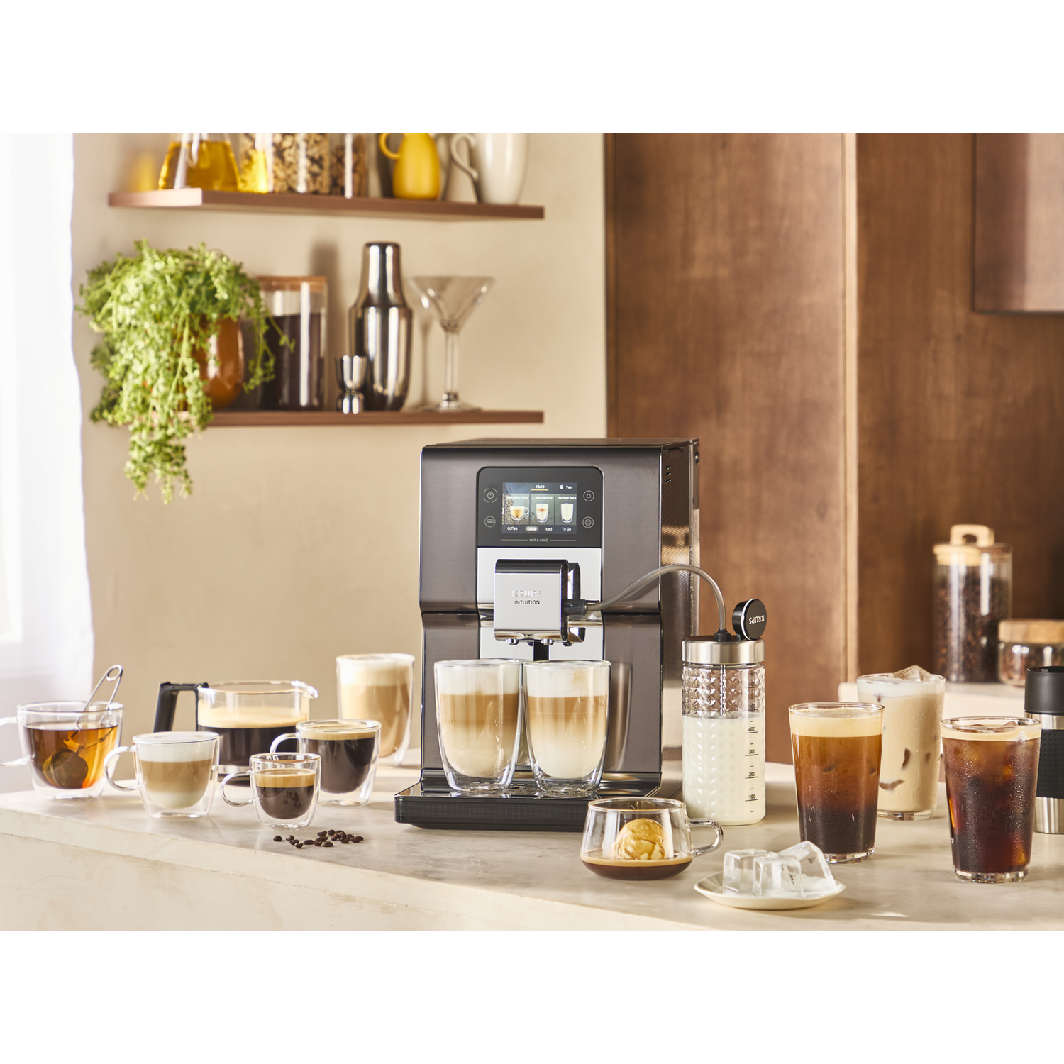 Koffiezetapparaat met diverse koffies en theeën in glazen op een aanrecht.