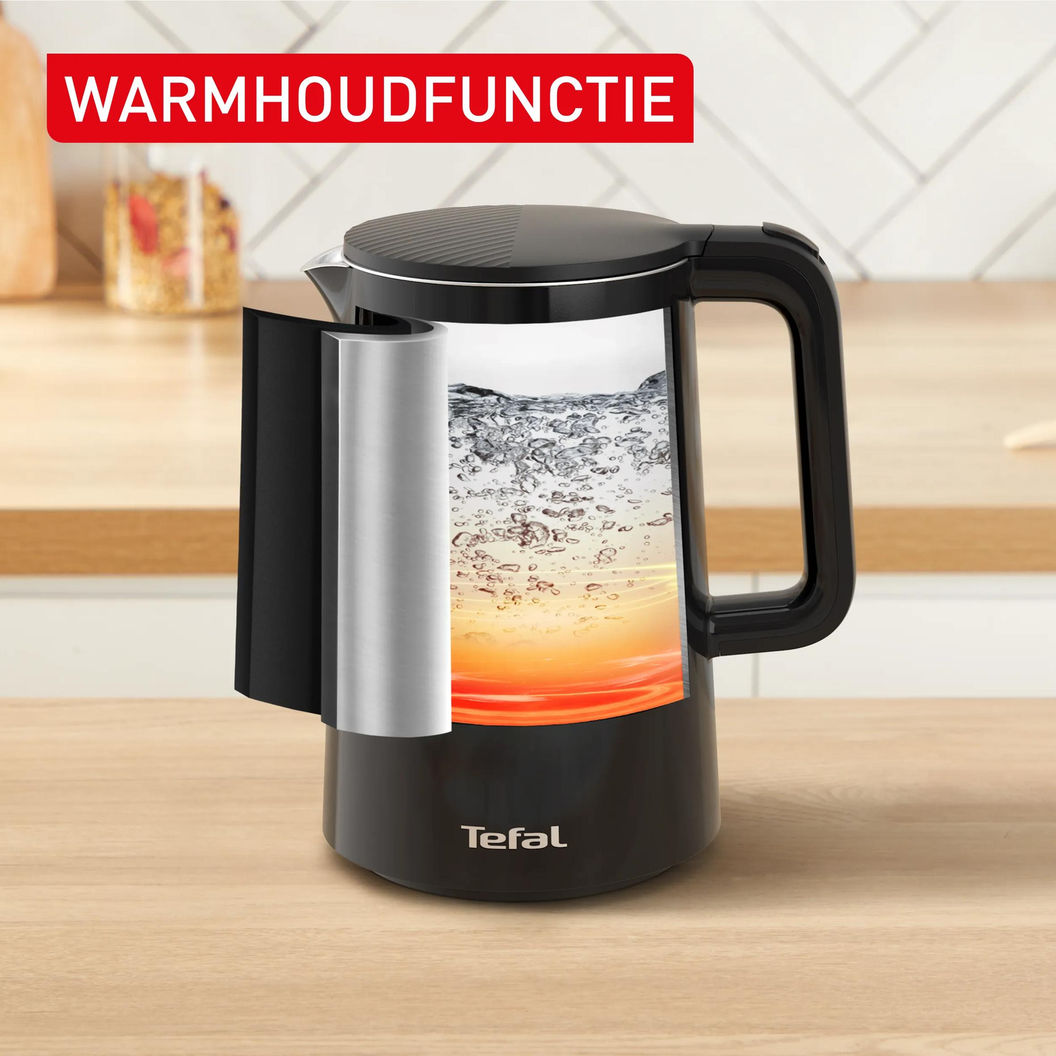 Zwarte waterkoker met warm water en warmhoudfunctie, op houten tafel.