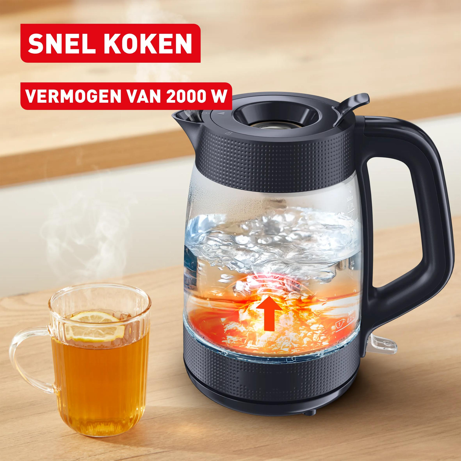 Een glazen waterkoker met zwart deksel en handvat, naast een kop thee.