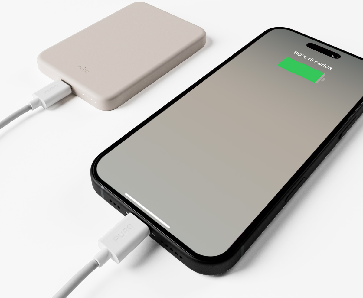 Ein beige Powerbank wird mit einem weißen Kabel an ein Smartphone angeschlossen.