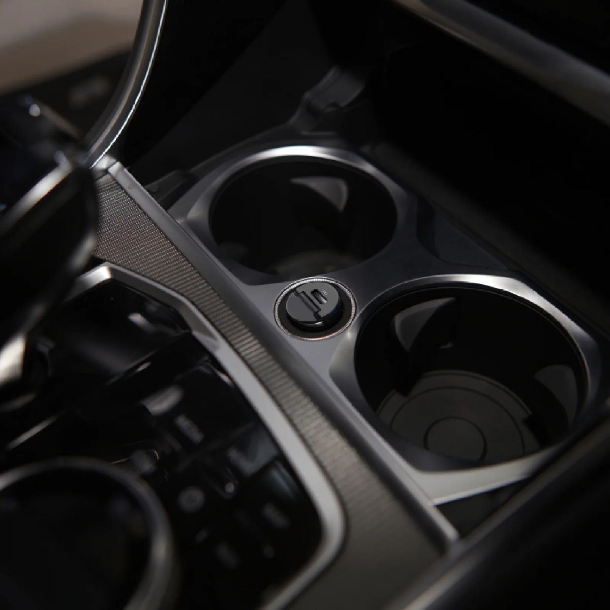 Detailansicht von zwei Auto-Getränkehaltern mit einem Aschenbecher-Symbol.
