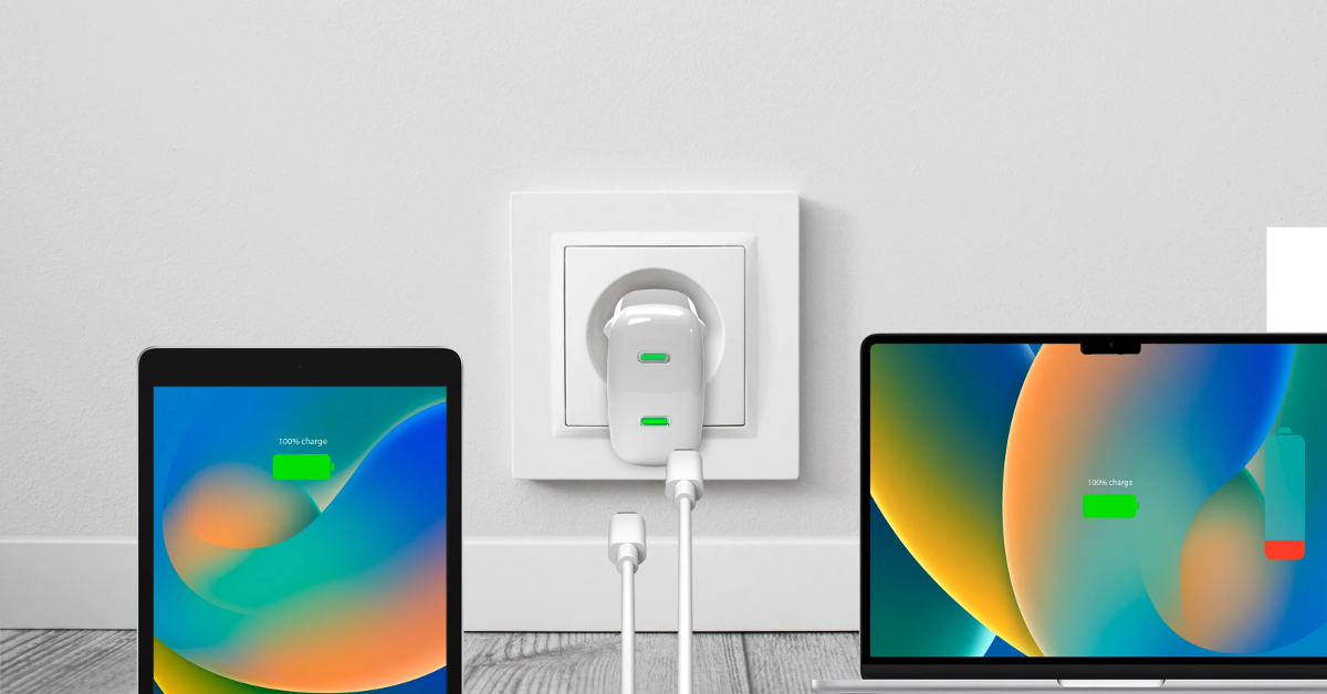 Tablet und Laptop laden an einer weißen Steckdose mit Dual-Port-Ladegerät.