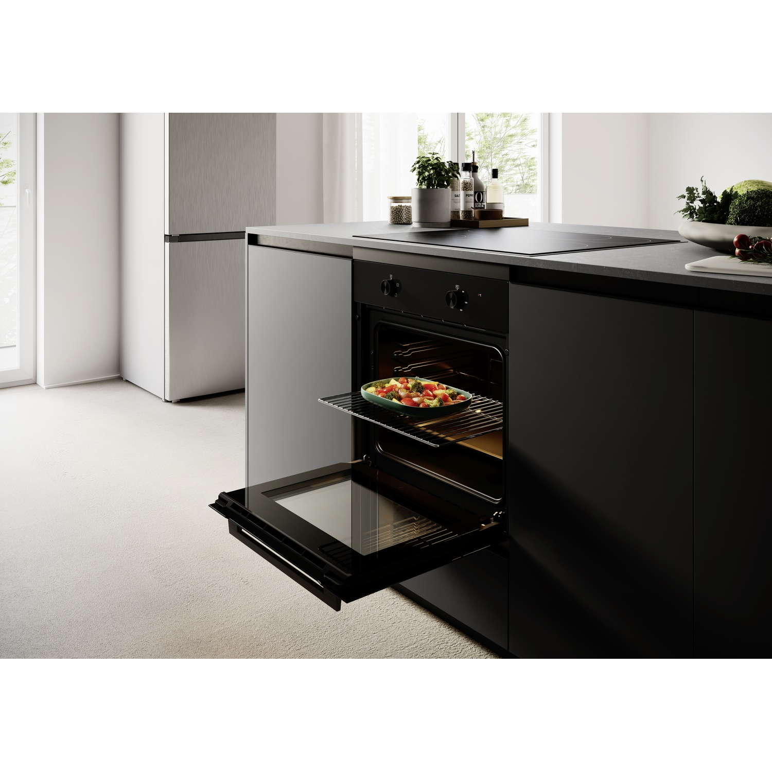 Una cucina moderna con forno aperto contenente un piatto di cibo e un frigorifero.