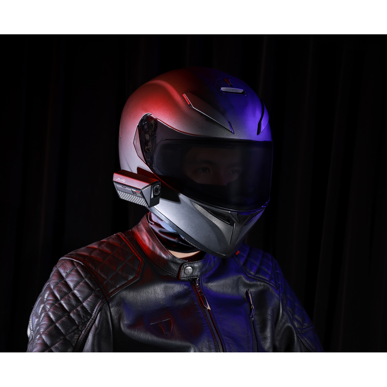 Persoon met helm en leren jas, verlicht door rood en blauw licht.