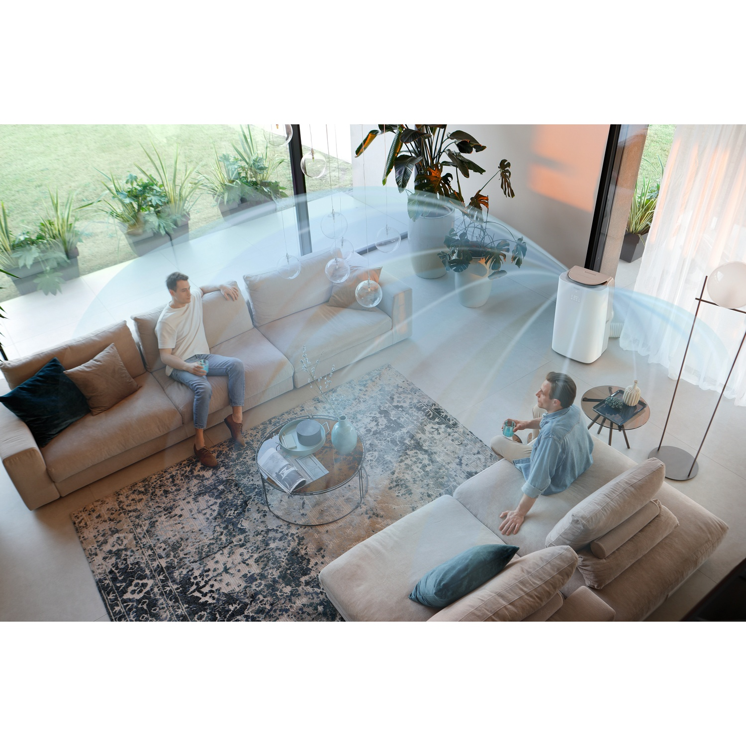 Two men sit on sofas in a modern living room, an air purifier blows air.