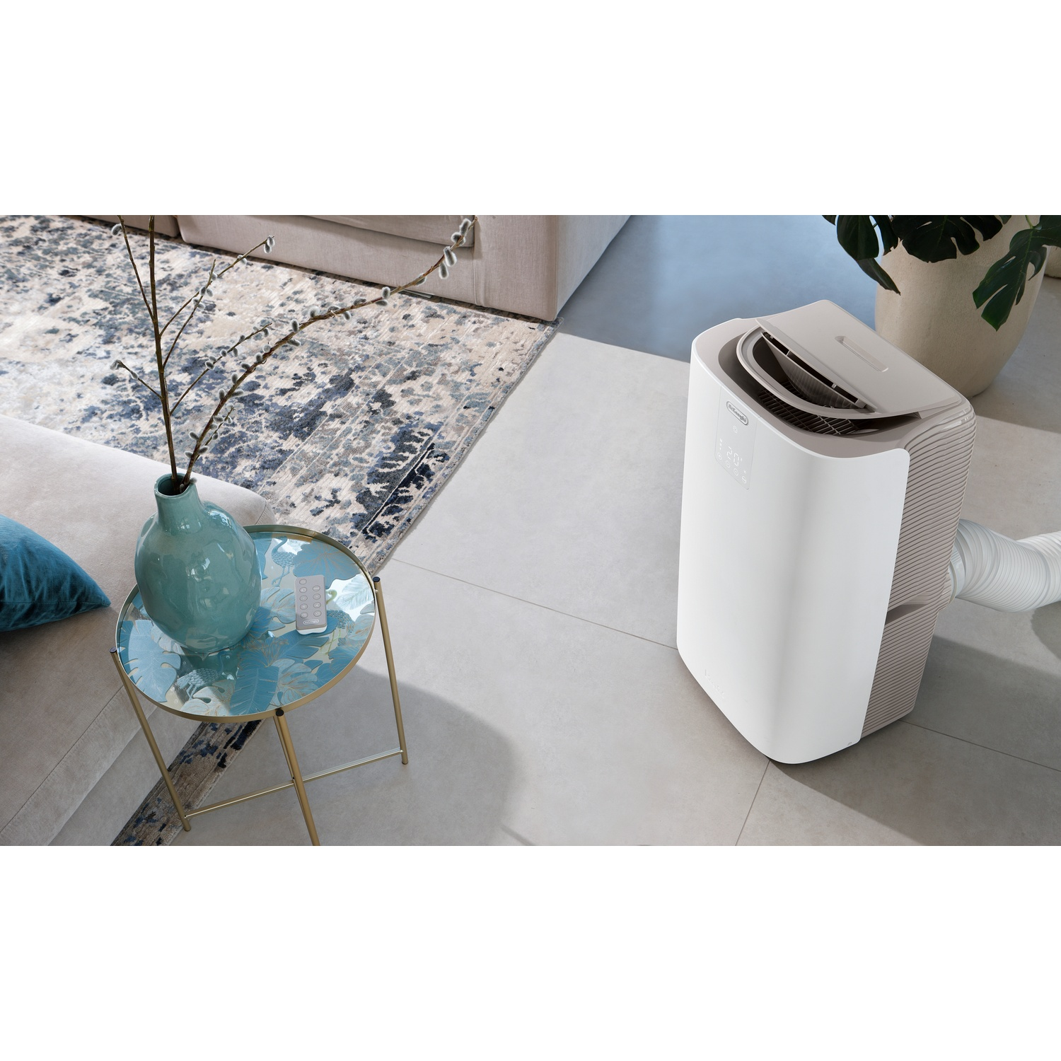 A white portable air conditioner next to a coffee table with a vase and rug.