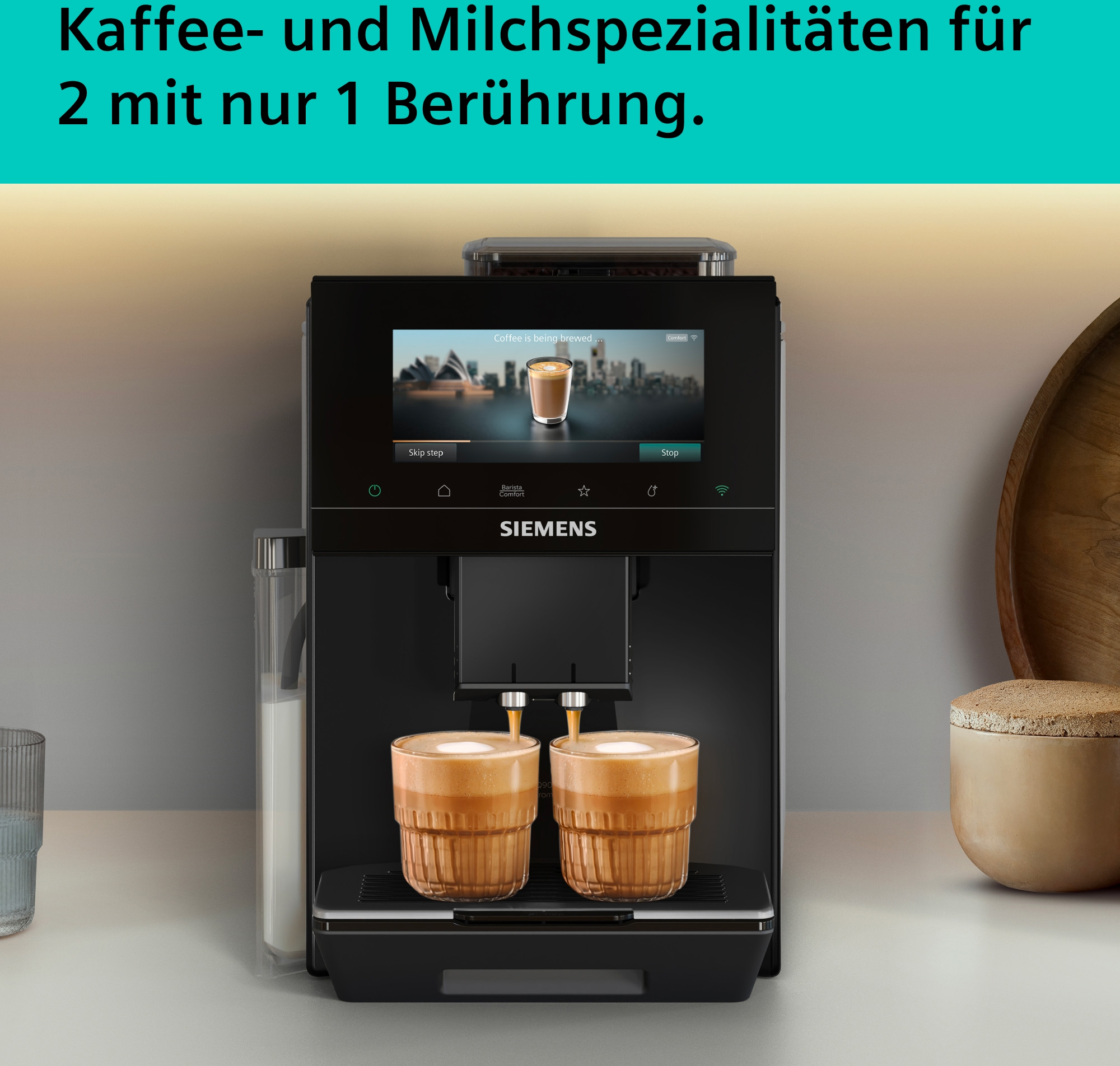 Eine schwarze Siemens Kaffeemaschine brüht zwei Cappuccinos in Glasbechern.