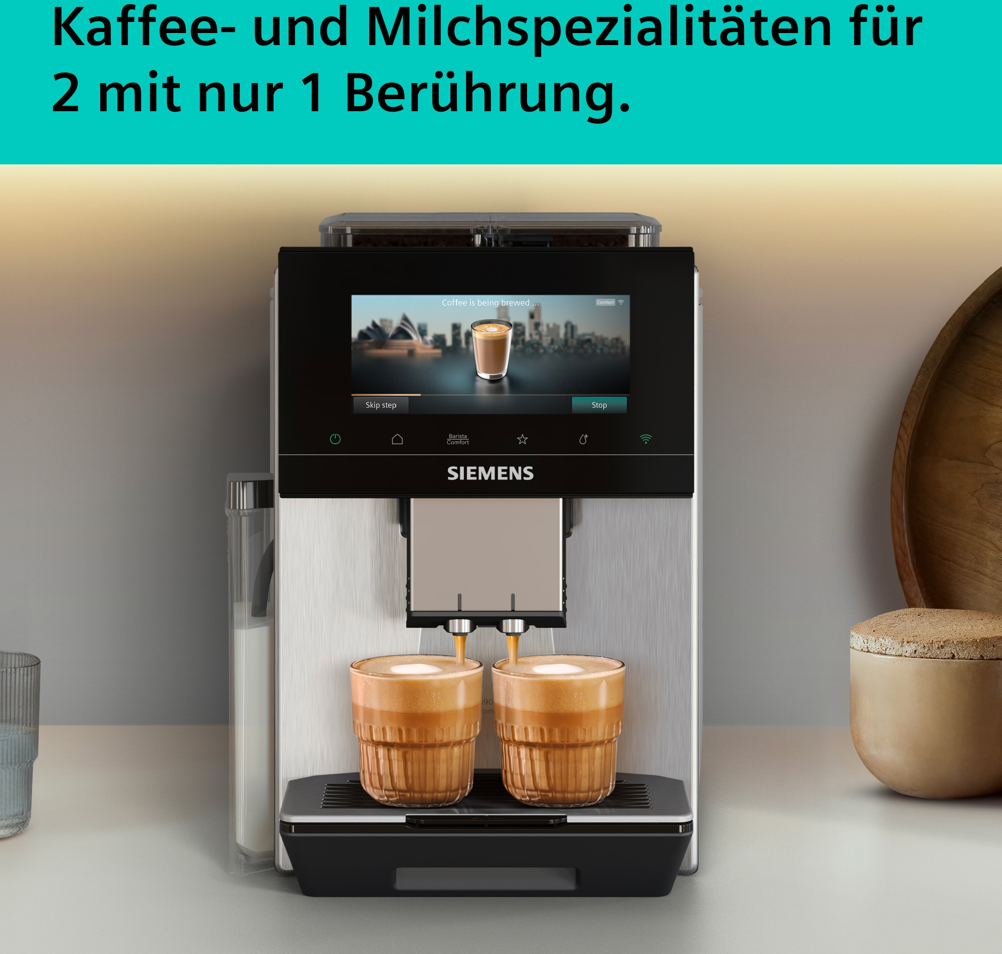 Kaffeemaschine bereitet zwei Kaffees zu. Milchbehälter links, Gläser rechts.