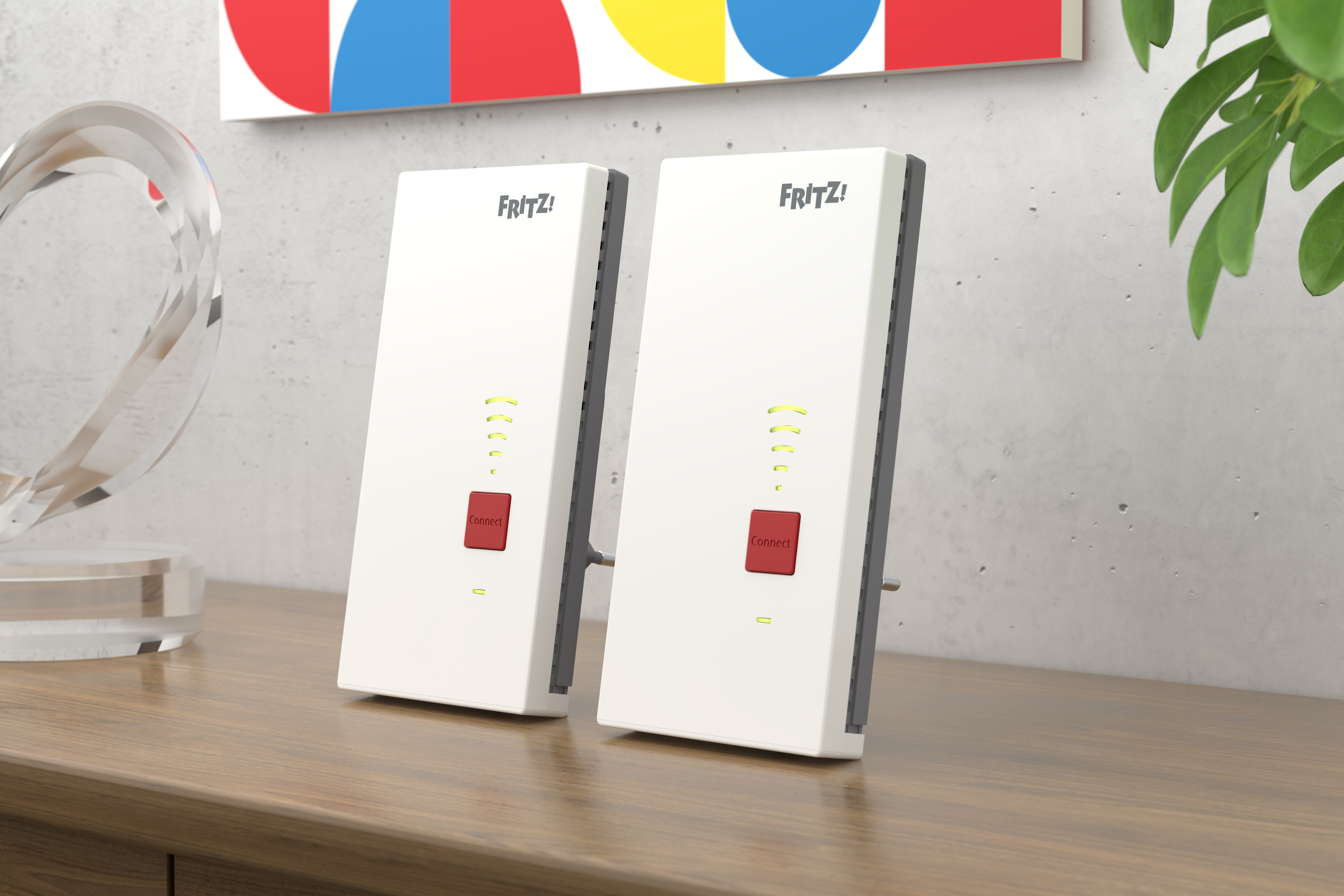 Zwei weiße Fritz!Box-Repeater mit rotem Connect-Button auf einem Holztisch.