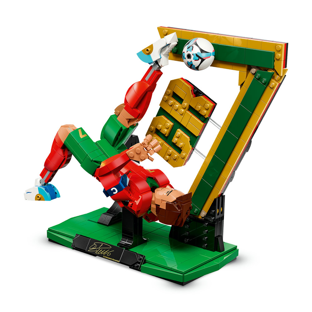 Ein Lego-Fußballer in Rot und Grün vollführt eine akrobatische Aktion mit einem Ball.