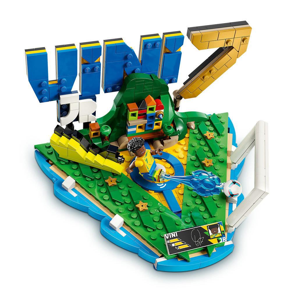 Lego Vini Jr. Fußballset mit Figur, Ball, Tor und bunten Gebäuden auf grüner Basis.