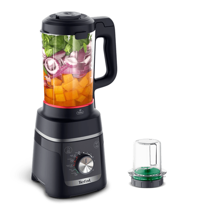 Schwarzer Tefal Mixer mit gewürfelten Kürbis, Zwiebeln und Kräutern gefüllt.