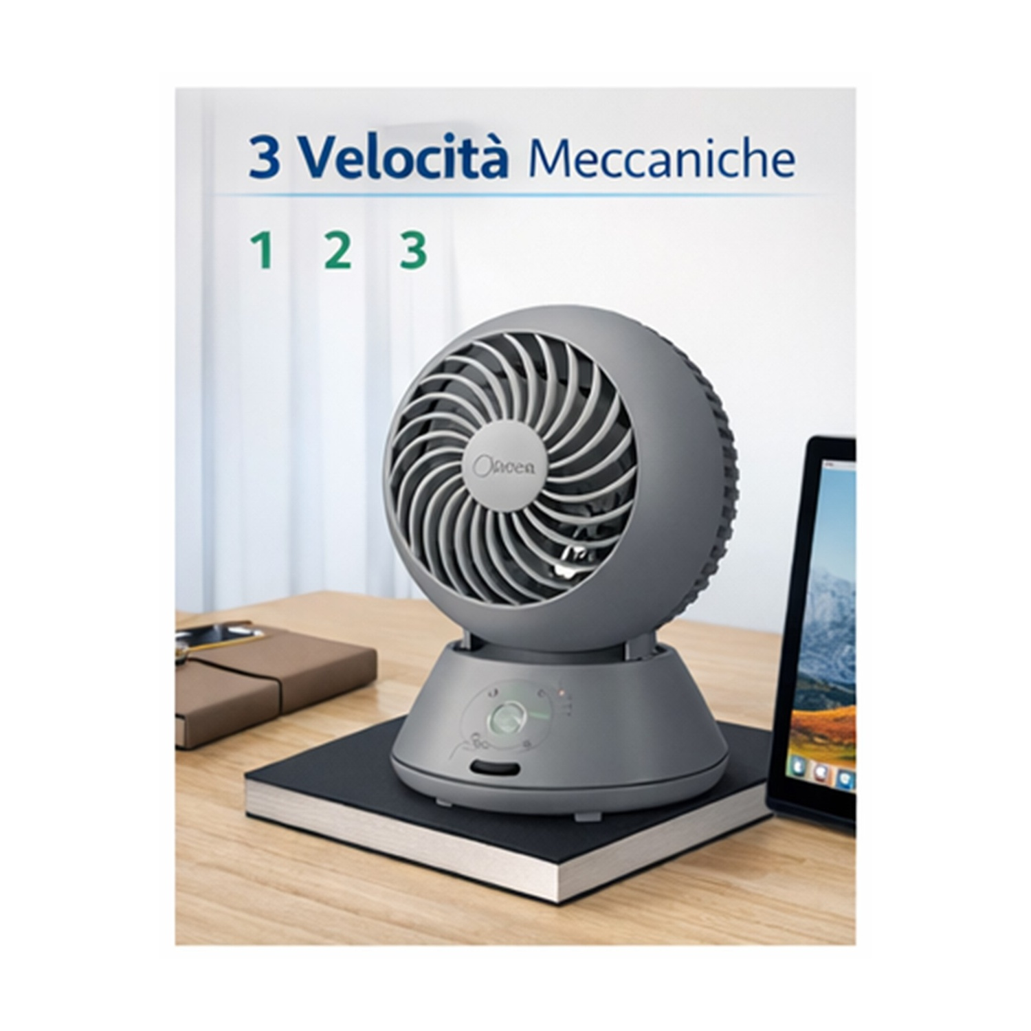 Un ventilatore da tavolo grigio a tre velocità è appoggiato su un quaderno.